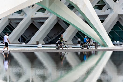Futuristic building in Valencia with reflections of pedestrians and bikes in a pond. bicicletário
