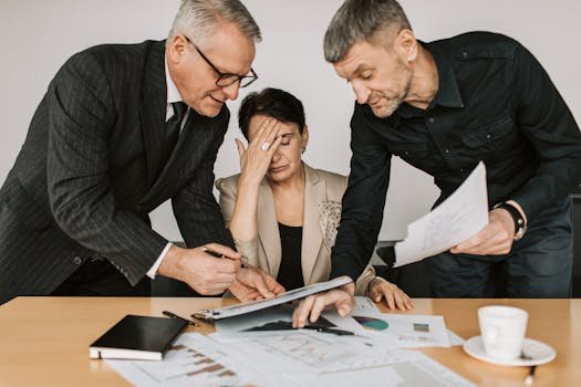A professional team in a tense business meeting discussing financial documents. inadimplência
