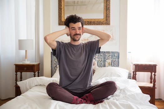 A serene portrait of a man meditating while sitting on a bed in a cozy, sunlit bedroom. lei do silencio