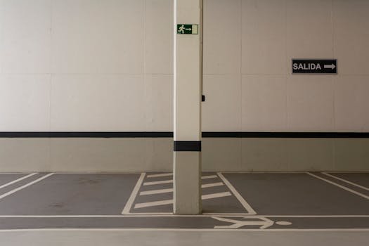 Minimalist underground parking area with exit signs and marked pathways. garagem