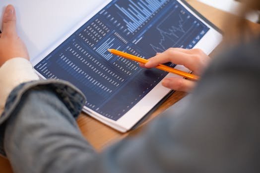 Focused image of hands analyzing business graphs and charts in a folder, highlighting data insights. balancete