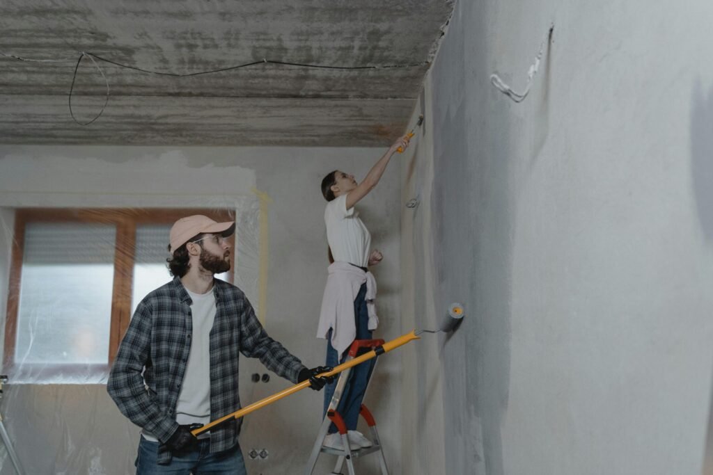 A couple painting a room together, highlighting teamwork in home renovation.