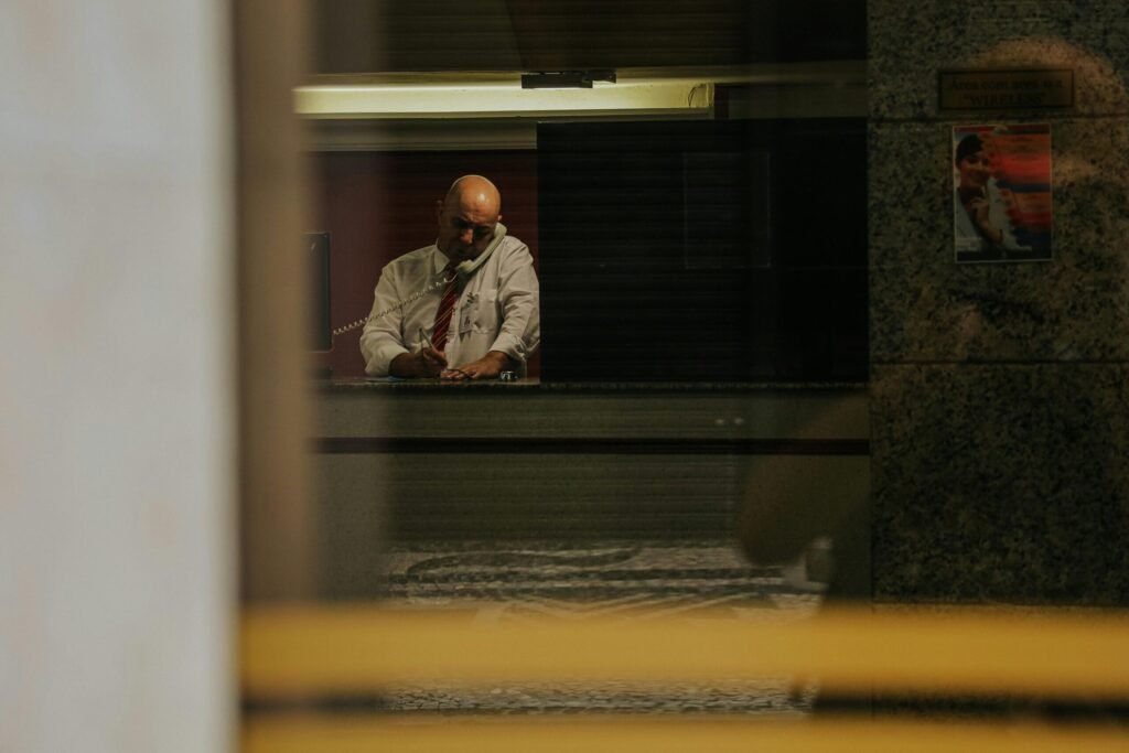 Businessman talking on the phone in a modern office viewed through a window in Curitiba, Brazil.