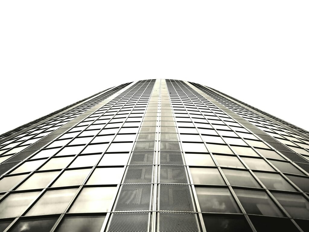 Low angle shot of a modern skyscraper with a glass facade and steel structure.